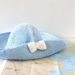 Crochet sun hat with wide brim and bow brooch in sky blue.