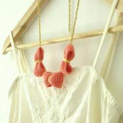 Three crochet bows necklace. Coral pink, golden chain.
