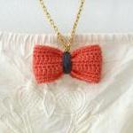 Crochet bow pendant. Salmon pink and grey cotton yarn.